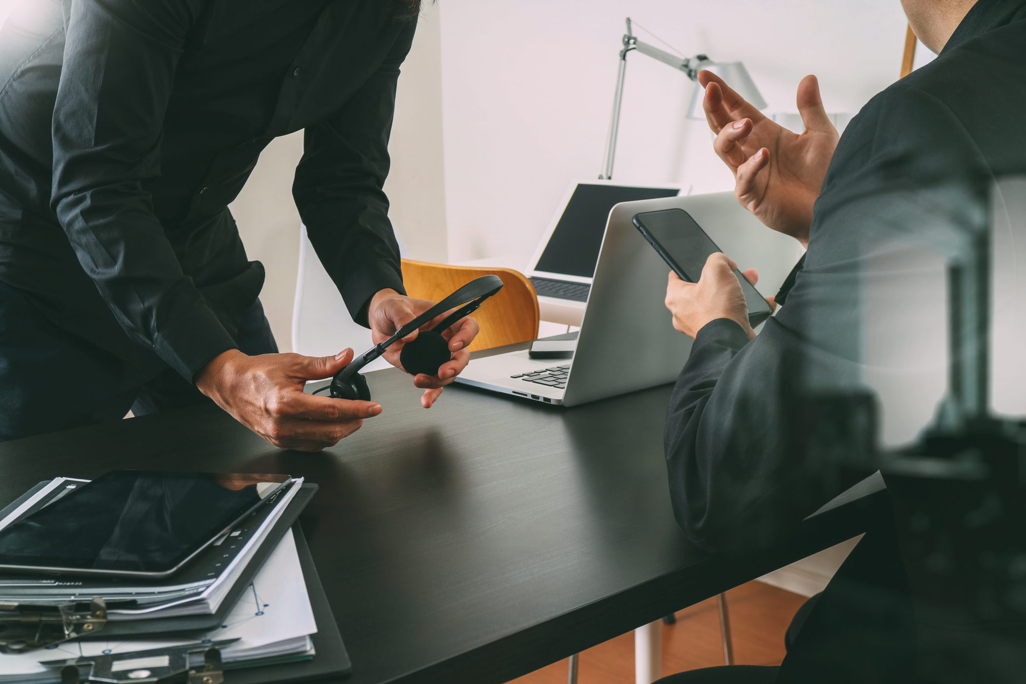 co working meeting,two businessman using VOIP headset with latop computer on desk in modern office as call center and customer service help desk concept